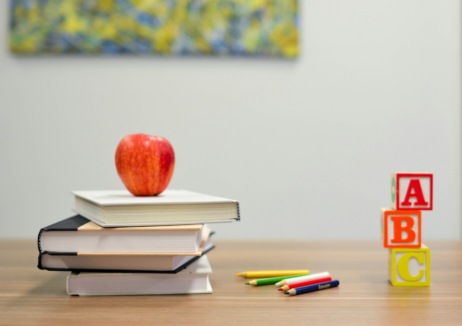 Books, pencils and ABC blocks on a school desk